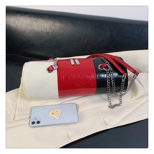Detailed close-up of a three-color cylinder bag with silver chain and dual zippers