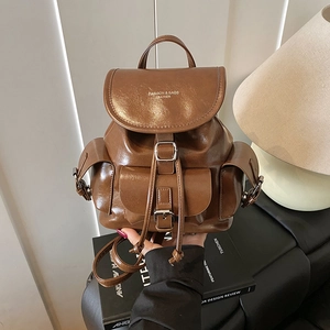 Brown vintage faux leather backpack with multiple buckled pockets and drawstring closure