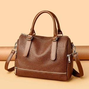 Detailed view of dark brown woven texture handbag with silver zippers and dual handles