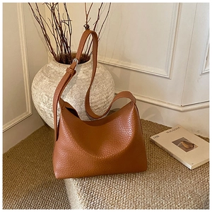 Texture détaillée du sac Hobo en cuir grainé marron avec bandoulière réglable et boucle argentée