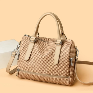 Detail of woven Boston bag featuring beige mesh texture and smooth leather strap handle