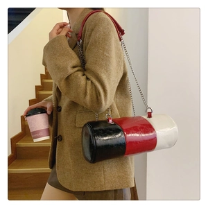 Detail of a tricolor cylinder shoulder bag with glossy pleated texture and chain strap