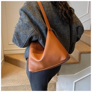 Détail de la texture cuir grainé caramel du sac bandoulière tendance style dumpling