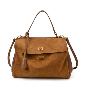 Brown suede tote bag with leather straps and gold metal lock on white background