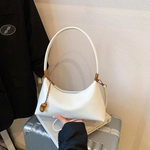 Sac demi-lune blanc avec chaîne dorée et pendentif, présenté sur un fond texturé