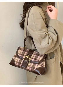 Close-up of retro plaid tweed handbag featuring a gold ring buckle and leather trim