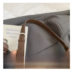 Close-up of brown lychee texture leather bucket bag with silver metal adjustment buckle