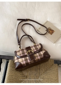 Detailed macro view of pink and brown plaid wool handbag with retro golden D-ring buckle