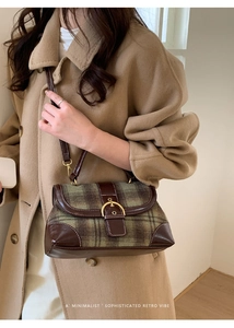 Detail of vintage green plaid handbag with brown leather trim and gold saddle buckle