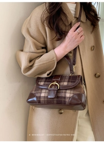Detailed close-up of retro plaid handbag with gold buckle and leather trim on wool coat