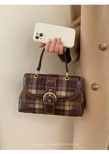 Detail of vintage brown plaid handbag featuring wool fabric and golden buckle decoration