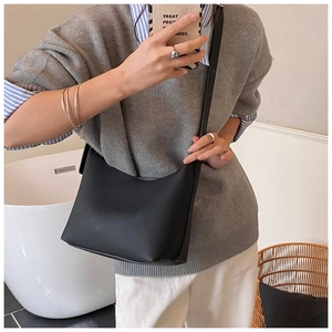 Black leather hobo bag with litchi texture shown in a modern home lifestyle setting