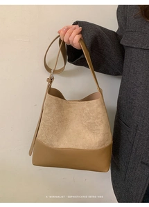 Gros plan sur les coutures vintage en daim et simili cuir kaki sur le sac seau chic