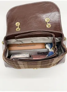 Top view of open plaid handbag interior showing spacious compartments and items