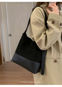 Gros plan d'un sac porté épaule en daim noir porté par un mannequin dans un décor intérieur