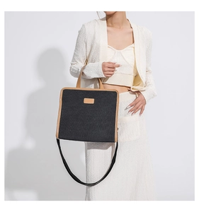 Detail of grey canvas tote with brown leather trim and detachable shoulder strap