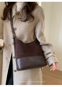 Détail d'un sac porté épaule en daim marron rétro avec bandoulière et texture fine