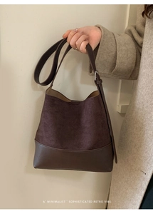 Détail du sac seau rétro en daim marron foncé avec bandoulière en cuir réglable