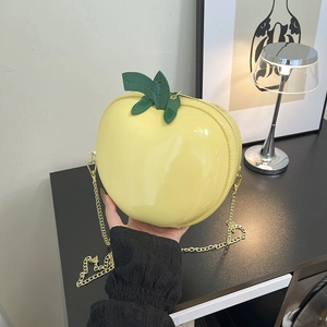 Creative apple-shaped crossbody bag in bright yellow faux leather with gold chain strap