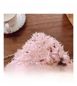 Close-up of pink faux fur bucket bag with sequins and silver metal chain strap