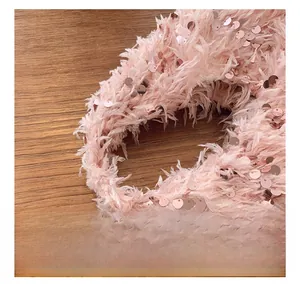 Detail showing pink feather bucket bag handle with sparkling sequins and luxury texture