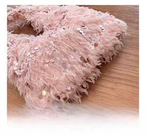 Macro detail of pink faux fur evening bag featuring shiny sequins and soft texture