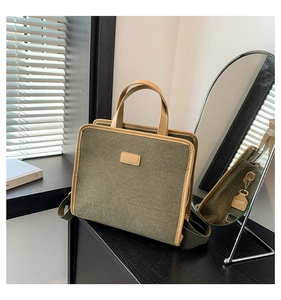Detail of army green canvas tote bag with leather trim and adjustable shoulder strap