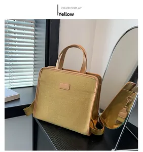 Detail view of mustard yellow canvas crossbody bag with wide strap and top handles