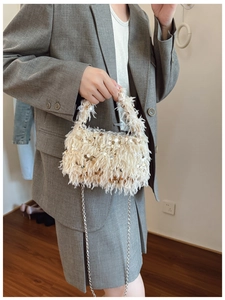 Detail view of mini off-white fuzzy handbag with gold sequins and metal chain strap