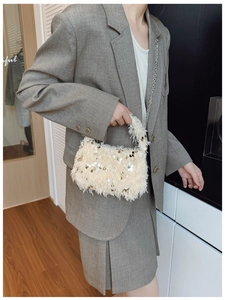 Detailed shot of cream faux fur evening bag with gold sequins and chain strap