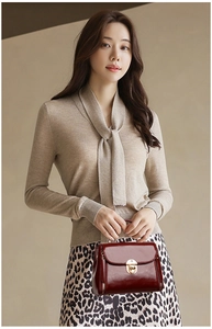 Detail showing deep reddish-brown leather handbag with a gold metal clasp lock