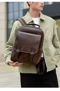 Detail of dark brown leather backpack with retro double buckles in urban outdoor setting