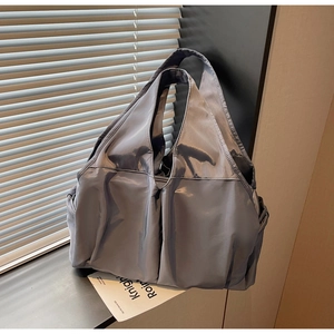 Detailed view of the large capacity tote bag with side pockets and smooth nylon texture
