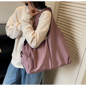 Detail of the large mauve tote bag showing side pocket and high-density nylon texture