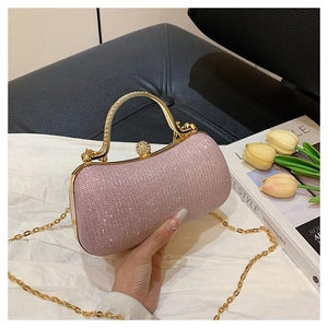 Detail of pink rhinestone evening bag featuring a gold round handle and ball clasp closure