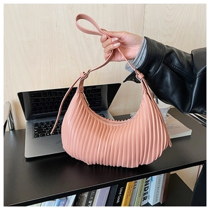 Détail du sac hobo rose avec texture plissée verticale et bandoulière réglable