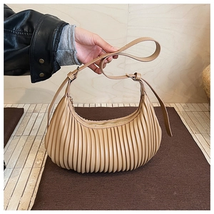 Vue détaillée du sac en croissant plissé beige avec rayures verticales et lanière