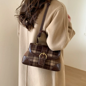Retro plaid crossbody bag with brown leather accents and gold buckle on camel coat model
