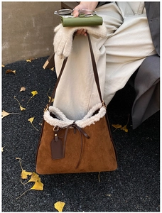 Nahaufnahme der braunen Wildledertasche mit weißem Kunstfellbesatz und Lederschleife