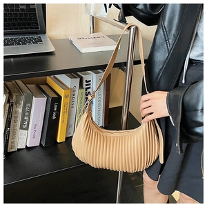Détail du sac croissant plissé beige montrant la texture du cuir PU et la bandoulière
