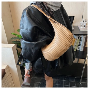 Vue détaillée du sac hobo beige présentant une texture plissée en accordéon unique