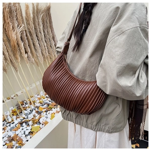 Détail du sac demi-lune plissé marron foncé avec texture verticale et bandoulière