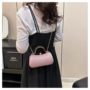 Detail of pink rhinestone clutch with gold handle and chain shown on model