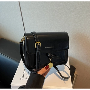 Detail of black glossy PU leather bag with gold hardware and FASHION & BAG lettering