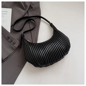 Détail du sac croissant noir avec texture plissée verticale et finition mate élégante