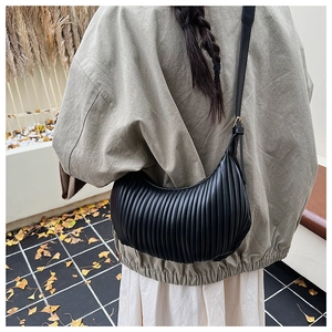 Détail du sac croissant plissé noir avec un motif à texture verticale élégante