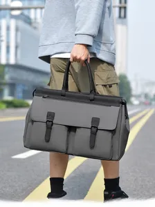 Detail of grey travel bag featuring two front buckle pockets and durable handles