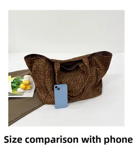 Detailed size comparison of leopard print canvas tote bag with a blue smartphone