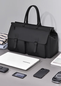 Detail of black business travel bag showing waterproof fabric and multiple pockets with laptop