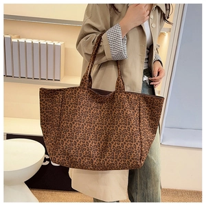 Leopard print canvas tote bag styled as a shoulder bag in a modern home interior